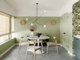 Dunn Edwards “Lichen Green” covers the walls. An Eero Saarinen Tulip Table with a Carrara marble top is surrounded by Oak Bok dining chairs from Burke Decor. The handmade chandelier is from Aka Charlie Studio, located in Tel Aviv, and found on Etsy.