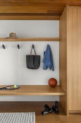 Hallway and Cork Floor Custom cabinetry extends into a mudroom area, which features BluDot Wook wall hooks in black.