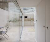 A wall of glass and clear roof significantly brighten and enlarge the back room, which now has a small kitchenette at the back wall.