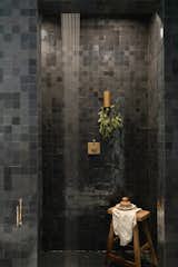 Mattingly encased the shower in two-inch-by-two-inch zellige tile from Clé, in Battled Armour.