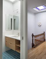 The balance of new and old can be seen in how the kid’s bath received all new finishes, while Kaplan kept the floors, stair rail, and stained-glass skylight in the hall. “Throughout the day, as the sun moves, that color [from the stained-glass] just moves around and then hits the property line wall, and goes all the way down the stair,” says Kaplan.