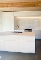 Clutter is kept to a minimum, thanks to a concealed pantry behind the stove wall, accessed through the door to the left. “It’s like a secret room,” says Bassett.