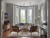 “Those living rooms are always a challenge in brownstones, to furnish in a thoughtful way,” says Cuttle, pointing to the narrow dimensions of the room, the low window sills, and abundance of woodwork taking up wall space. A curving Carl Hansen sofa floats in front of the bay window, so as not to block the light and allowing easy sightlines. The chairs and coffee table are from Lawson Fenning and the rug is Jardan.