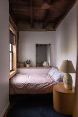 A full-sized mattress tucks into the corner for a perfect view of the maple tree outside the window.
