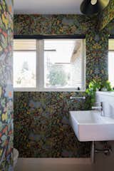 Bath Room, Porcelain Tile Floor, and Wall Mount Sink The powder room is wrapped in Josef Frank wallpaper.