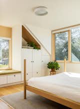 Bedroom, Bed, Storage, Medium Hardwood Floor, Bench, Shelves, and Ceiling Lighting Custom shiplap cabinetry saves floor space, and visually links the bedrooms to the rooms downstairs.