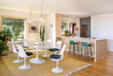 Dining Room, Ceiling Lighting, Chair, Medium Hardwood Floor, Stools, Pendant Lighting, and Table SHED removed dividing walls to expand the kitchen. A peninsula counter separates the space from the dining room.