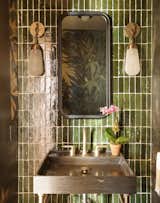 In the powder bathroom, bespoke Calico wallpaper can be seen in the mirror, which is set against a backdrop of green Cle tile. “That’s our Miami experience,” says Kristi.