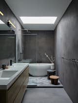 The bathroom is a “compromise” for the couple, as Michelle didn’t want tile, and Augustin preferred the space to have a darker wall finish. They agreed to ensconce it in charcoal-colored plaster. The stools are by River Valadez.