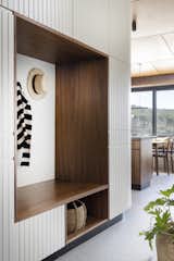 An entry nook framed in walnut is a spot to drop bags, shoes, and coats.