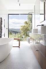 Silver white marble on the walnut vanity complements the granite floor.