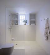 A large walk-in shower has Tadelakt plaster applied by Sobro Studios, and integrated storage.