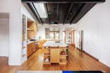 Engelsman gave the kitchen an L-shaped layout with a large island workspace at the center, and pushed the tall storage into the garage, to create a wide circulation space to access the dining room and backyard.