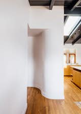 The curved wall marks the entrance to a hallway with two bedrooms and a bathroom. When the kitchen expanded in size, Engelsman was faced with the problem of the hallway being squeezed too tightly. “One day I was like, ‘Why don't we just curve it over to the bathroom door,’” says Engelsman. “We got an extra eight – ten inches by having it curve instead of come to a sharp corner.”