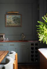 The wet bar was given a custom cherry top, and the couple added wall molding for texture.