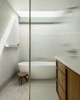 The design team added a skylight to the shower room, which has a ribbed glass partition and wall tile from Solistone.