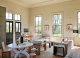 The contractor rebuilt the coved ceiling with plywood, and restored the original windows, wainscot, and chalk ledge atop the wainscot in the main room. The white table is by Joel Edmondson.