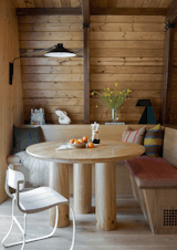 The white oak bench seating wraps a vintage wood table found on OfferUp. The custom cushions are by Legacy Custom Upholstery in Perennials’ Raffia fabric in Geranium Red. The wall light is the Schoolhouse Gantry Pivot Sconce.