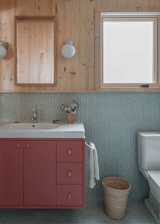 Emily designed the floating vanity and had it painted in Benjamin Moore’s Baked Terra Cotta, with a Duravit sink top.