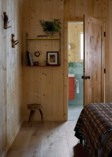 The bed features a Gregory Parkinson quilt, paired with a vintage Tomado wall rack and Juniper wall hooks from Etsy.