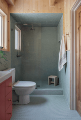 The couple raised the ceiling height in the bathroom, then lowered it in the shower to create a "jewel box" effect, enhanced by the Mint Gloss penny tile rounds from Mission Tile West that cover the ceiling, walls, and floor.