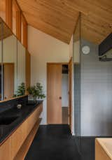 Bath Room, Ceramic Tile Floor, Freestanding Tub, Wall Lighting, Undermount Sink, Full Shower, and Ceramic Tile Wall In the primary suite, a custom vanity and medicine cabinets line the wall of the bathroom and a pocket door leads to the walk-in closet.