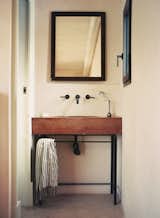 The custom vanity has an antique mirror above it.