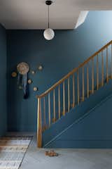 The staircase needed to be rebuilt to meet current building code, but being in basically its original location, is an anchor in the redesign. The wall color is "Hamilton Blue