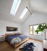 On the upper floor, the addition's raised roof height creates a vaulted ceiling in the primary bedroom.