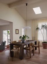 A Model 2026 pendant by Gino Sarfatti, purchased via rewire gallery in Los Angeles, hangs over the vintage table and woven chairs, all bought from Round Top Antiques Fair.
