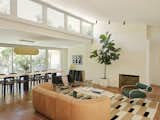 Lake Flato Architects extended the brick around the fireplace across the entire wall, then added a steel beam to be able to remove the columns and lift the ceiling height. Office of Tangible Space added a Sofa by De Sede, Rug by Beni Rugs, and chair by Shiro Kuramata for Cassina.