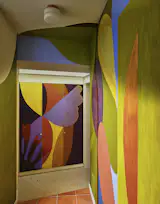 Office of Tangible Space tapped artist Rafael Uriegas for a mural to cover the hallway leading to the children's rooms.