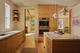The door to the left was added in the remodel, to increase air flow and facilitate better circulation for groups. The threshold is painted green, in a nod to an image seen in the Barbican Residents: Inside the Iconic Brutalist Estate. The wall oven are by Bosch.