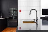 A bright red switch plate plays up the kitchen's contrast. The cabinets are IKEA with custom-designed doors.