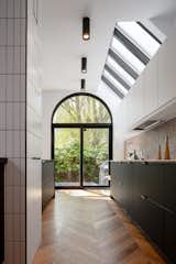 Engineered wood floors in a chevron pattern cover the ground floor. The semi-circular window is a reoccurring motif in the original Bernard Rasch design.