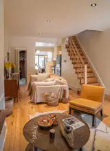 A West Elm chair, couch, and rug sit atop the new white oak floors. Eric brought home the antique copper sift from Turkey years ago and it's now the coffee table. The wall color is Benjamin Moore 'Acadia White.'