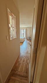 A stained-glass window gifted from April's parents brings light into the primary bathroom. Eric recreated the pattern in the wood floor with scraps of red oak, white oak, walnut and cherry. "That took a lot of time to mimic that [pattern],