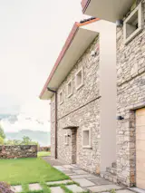 The stone is further tempered by the concrete window frames that protrude from the facade, an indentation or "reveal