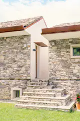 The dry stonewall construction contrasts with the smooth finish on the passage separating the two houses, and "creates tension,