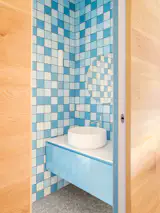 In the Casa B powder room, the floor-to-ceiling blue tile is from CE.SI.