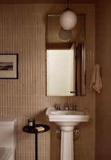 Walls are covered in Umi Torimu in Latte Glossy from DDS Tile with a Gentry Small Opal Glass Globe Pendant Light from Mullan Lighting on Etsy.