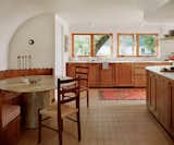 The team dropped the ceiling in the kitchen in order to be able to run lines for the air conditioner. The curved wall around the banquette conceals HVAC for the living room.