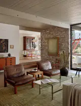 The preserved wood walls and ceiling are painted Benjamin Moore White Dove and the floors are concrete. The painting on the stone wall is by Kate Zimmerman Turpin.
