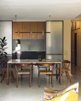 The architects added sliding glass panels between the kitchen and dining room to diffuse light. To do so, they sandwiched two panels of fluted glass to be perpendicular to each other and create a grid pattern, "so the light going through has a certain depth,