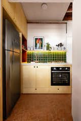 MadeMarchi created abundant cabinetry out of marine plywood with a clear finish to surround a new, full-sized refrigerator. White quartz counters and green tiles from Strufaldi complete the palette.