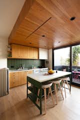 The dropped ceiling is old-growth fir that was discovered under plaster during the demolition phase of the project, and was repurposed for interior finishes. The custom island prep table is by Vintage Mill Werks, with Hay stools.