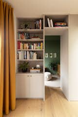 A custom bookcase designed and fabricated by Kevin with base cabinet fronts from Semihandmade separates the playroom from a bedroom, currently set up as Poppy's nursey.