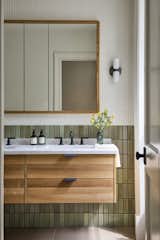 In the bathroom, there's G120 Lemon Ice tile by Heath Ceramics topped with Color Wheel Mosaic in Matte Biscuit by Daltile, and a Rejuvenation vanity. "Visiting the home after completion, I felt there's a sense of calm continuity as you walk through,