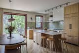 The custom kitchen millwork is designed by reBuild Workshop, and fabricated by Custom Lotus, with quartzite counters. The high stools in white oak are by Space Copenhagen.