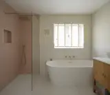 The wall tiles are Carter Ceramic Rose tiles by Ca’Pietra, in a herringbone pattern. The vanity unit is from Parker &amp; Howley, supplied by Tinkletorium.